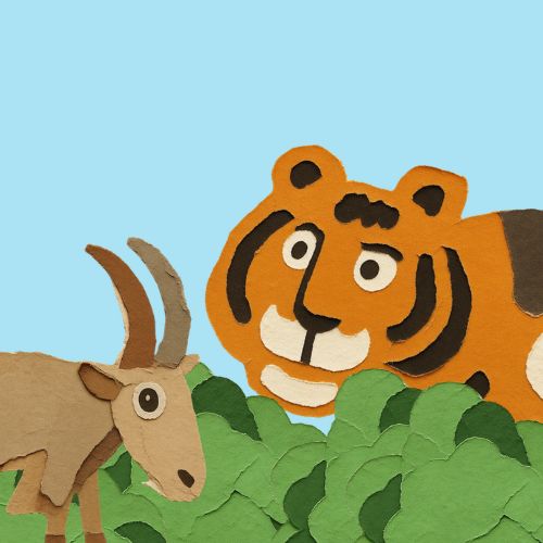 A paper cut-out illustration of an orange tiger hiding behind green bushes, watching a brown goat in the countryside.